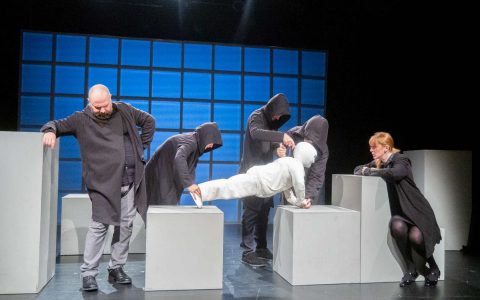 Grupa ludzi i lalka na scenie teatralnej