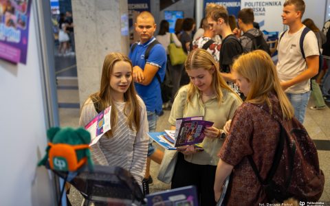 Grupa osób ogląda foldery rekrutacyne