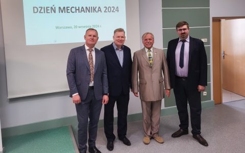czterech mężczyzn stoi na tle napisu dzień mechanika 2024