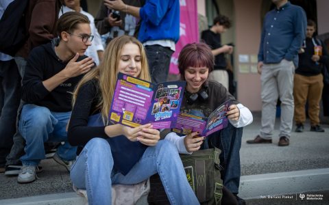 uśmiechnięta młodzież ogląda ulotki rekrutacyjne